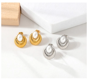 Detail of vintage oval pearl earrings with radiant shell texture in gold and silver finish