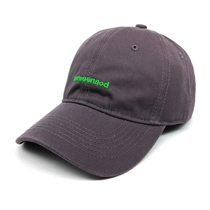 Detail of green betweenaod embroidery on a dark grey cotton baseball cap with twill texture