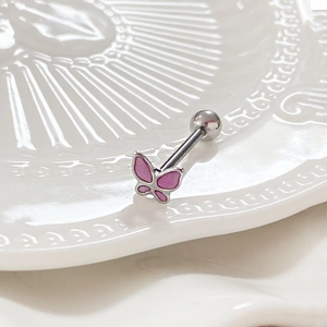Macro shot of a pink butterfly piercing stud on a white textured ceramic background