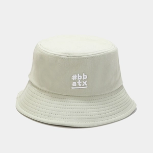 Detailed close-up of 'bb atx' embroidery on light green cotton canvas bucket hat