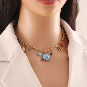 Gold layering necklace with celestial charms and a blue heart worn by a model