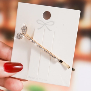 Sparkling gold fishtail hair clip with inlaid rhinestones on a white card display