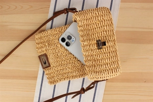 Detailed interior of a woven straw crossbody bag showing its capacity for a smartphone