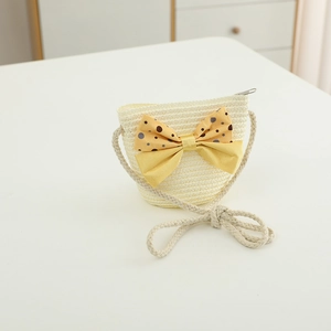 Detail of children straw crossbody bag with yellow polka dot bow and cotton rope strap