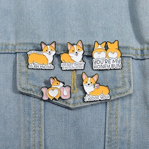 Lot de cinq épingles en émail Corgi orange sur la poche d'une veste en jean bleue