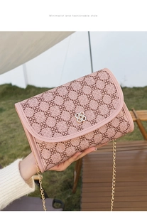 Détail du sac rose à motif trèfle avec fermoir pétale doré et bandoulière chaîne