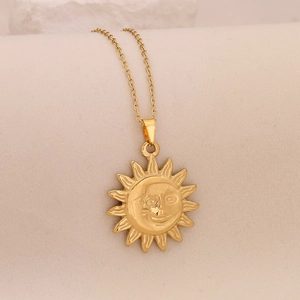 Detailed view of sun and moon pendant on gold stainless steel chain necklace