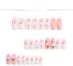 Detail of peach pattern press-on nails with 3D heart charms and green rhinestones