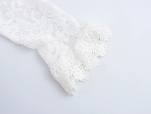 Gros plan détaillé des manches en dentelle florale blanche avec bords en crochet festonnés