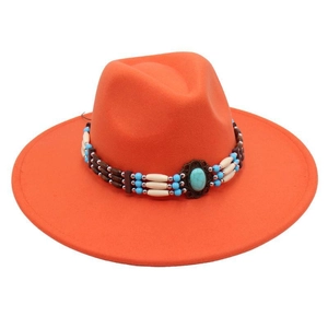 Macro shot of orange wool fedora hat with ethnic turquoise beaded band decoration