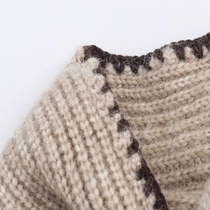Gros plan sur tissu en maille beige avec texture côtelée et bordures crochetées marron