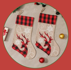 Close-up of red plaid Christmas stockings with embroidered reindeer and snowflakes