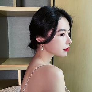 Model wearing vintage hoop earrings featuring elegant white freshwater pearls and gold finish