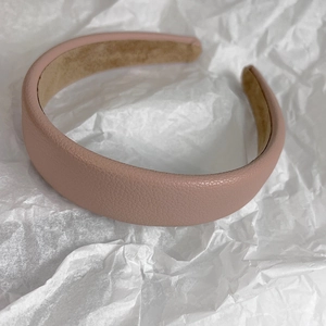 Close-up of pink litchi grain leather headband with khaki velvet lining detail