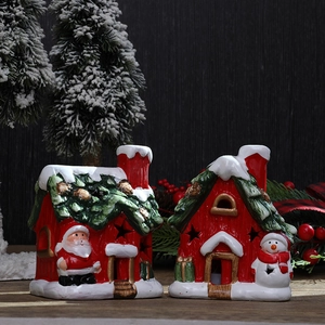 Ceramic Christmas house figurines with Santa and snowman on a festive wooden backdrop