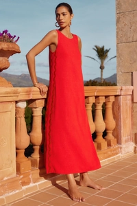 Detail of red sleeveless midi dress showing side lace embroidery and linen texture fabric