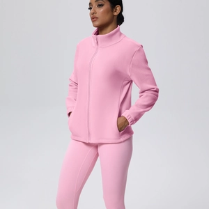Dettaglio del set yoga in pile rosa con giacca con zip e leggings sportivi attillati