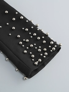 Detailed close-up of black dress sleeve cuffs featuring elegant silver beaded embellishments