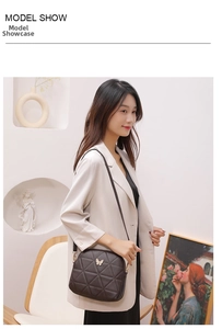 Detail of a brown quilted crossbody bag with a golden butterfly clasp worn on a white coat