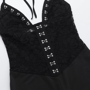 Detailed close-up of intricate black lace texture and decorative metal hook fasteners