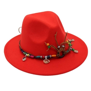 Detail of red fedora hat featuring bohemian style handmade beads and seashell trim decor