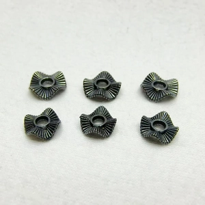 Detailed view of six flower-shaped wavy spacers in dark gray alloy for DIY jewelry making