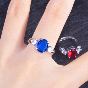 Detailed macro view of the oval-cut blue gemstone ring featuring three-stone silver setting