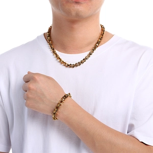 Close-up of gold titanium steel curb chain necklace and bracelet on model