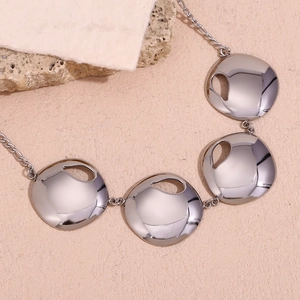 Macro shot of silver plated irregular round metal pieces with hollow design necklace