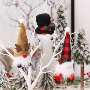 Three glowing Christmas gnomes hanging on white branches with festive LED lighting