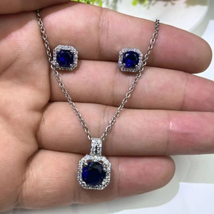 Silver necklace and stud earrings set with deep blue round gemstones and small zircons