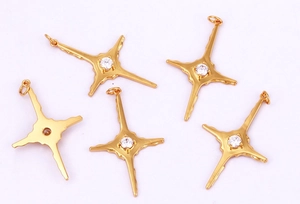 Detailed view of five gold four-pointed star pendants with inlaid cubic zirconia
