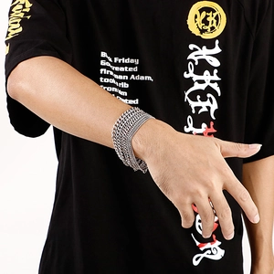 Detail of multi-layer stainless steel Cuban chain bracelet on male model wrist