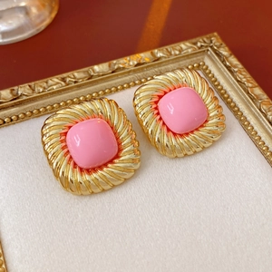 Detail von Vintage Gold-Ohrringen mit rosa Harzstein in einem klassischen Rahmen