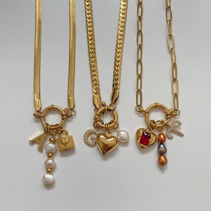 Gold paperclip and curb chain necklaces with pearls, heart pendants and letter charms