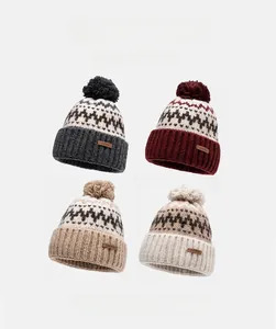 Detail of four colorful knit beanies with fluffy pom poms and textured jacquard pattern