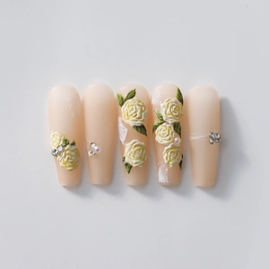 5D embossed coffin nails with yellow roses, white pearls, and rhinestones on nude base