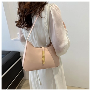 Detail of nude pink shoulder bag with a sleek golden metal clasp and smooth leather