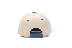 Détail de la casquette bébé beige montrant la sangle arrière bleue et les œillets
