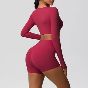 Detail of berry red long sleeve crop top and high waist yoga shorts set on model