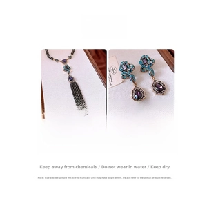 Detail of vintage teardrop pendant necklace and earrings with purple gems and blue crystals
