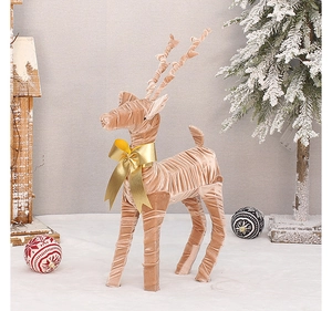 Close-up of elegant beige velvet Christmas reindeer ornament with a golden bow detail