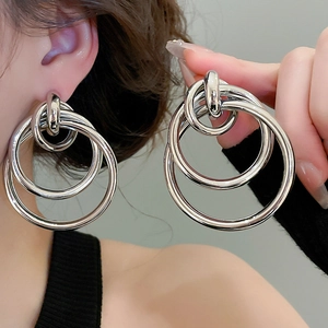 Vue détaillée des boucles d'oreilles triple anneaux en argent poli au design multicouche