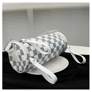 Detail of the checkered cylinder crossbody bag with silver hardware and textured fabric