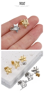 Detail of star-shaped 18k gold stud earrings with hammered texture and butterfly backs
