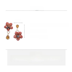 Détail de boucles d'oreilles fleurs rouges en tissu avec strass et cristal de 7cm