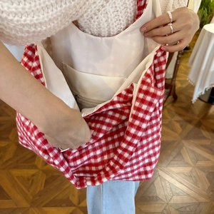 Detail view of red checkered tote bag with white lining and inner zipper pocket