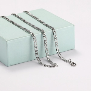 Close-up of a polished silver Figaro chain necklace with a secure lobster clasp closure