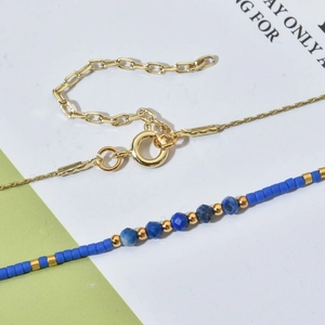 Collier en chaîne dorée avec perles de cristal bleu facettées et fermoir à ressort