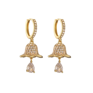 Detailed macro view of gold drop earrings with white zircon pavé and teardrop stones